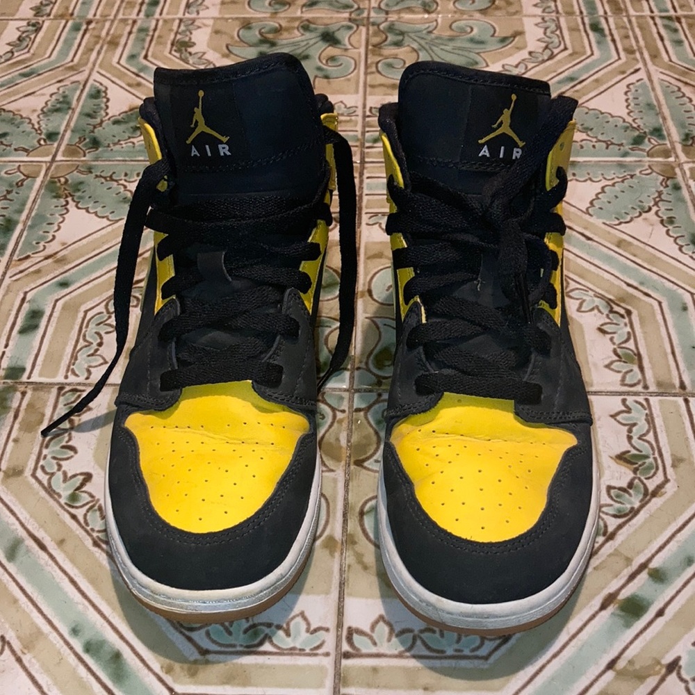 Air Jordan black and yellow running shoes. Visible walking creases.